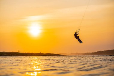 Uçurtma. Bir sörfçü gün batımında güzel bir köprü ve sahil şeridinde sörf yapar ve her türlü gösteriyi sergiler. : Yogyakarta, Endonezya - 26 Ağustos 2023