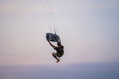 Uçurtma. Bir sörfçü gün batımında güzel bir köprü ve sahil şeridinde sörf yapar ve her türlü gösteriyi sergiler. : Yogyakarta, Endonezya - 26 Ağustos 2023