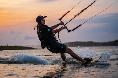Uçurtma. Bir sörfçü gün batımında güzel bir köprü ve sahil şeridinde sörf yapar ve her türlü gösteriyi sergiler. : Yogyakarta, Endonezya - 26 Ağustos 2023