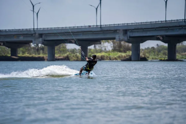キットサーフィン 男性サーファーは 橋や海岸線の美しい背景に乗って あらゆる種類のスタントを実行します スポーツ レジャーのコンセプト インドネシア ジョグジャカルタ 2023年8月26日 — ストック写真