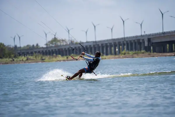 キットサーフィン 男性サーファーは 橋や海岸線の美しい背景に乗って あらゆる種類のスタントを実行します スポーツ レジャーのコンセプト インドネシア ジョグジャカルタ 2023年8月26日 — ストック写真