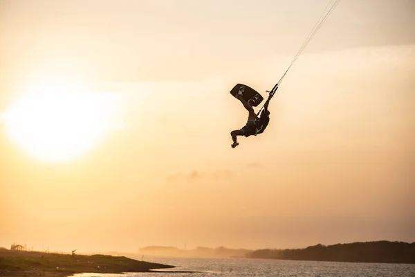 キットサーフィン サーファーは 日没時に橋や海岸線の美しい背景に乗り あらゆる種類のスタントを実行します インドネシア ジョグジャカルタ 2023年8月26日 — ストック写真