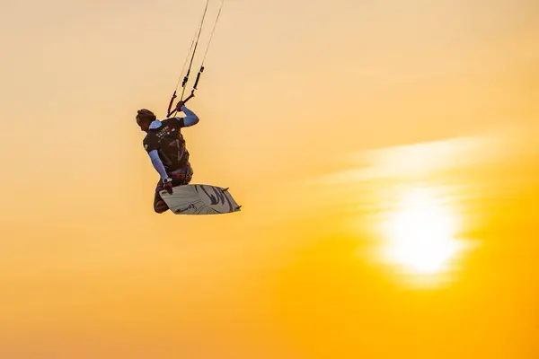 风筝冲浪 一个冲浪运动员在日落时骑在美丽的桥和海岸线的背景上 表演各种特技表演 印度尼西亚日惹 2023年8月26日 — 图库照片