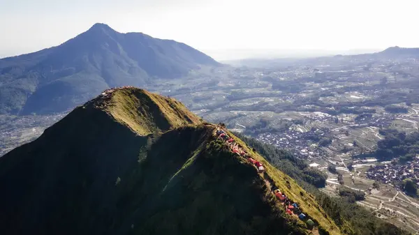 Aerial view of the peak of Mount Andong in Magelang in the morning. You can see climbers camping between the mountain slopes.