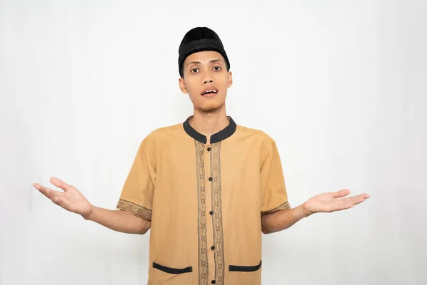 stock image Muslim Asian man wearing brown Muslim shirt feeling confused or not knowing. Isolated white background.