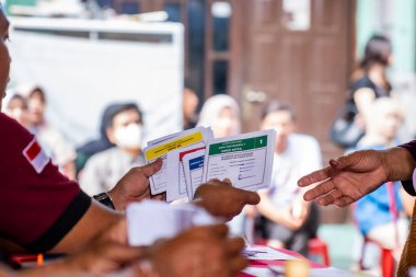 Yogyakarta, Endonezya - 14 Şubat 2024: Endonezya seçimlerinde seçmenlere oy kullanma belgeleri hazırlayan veya sunan bir oylama organizatörü grubu süreci.