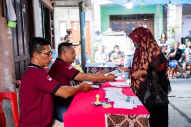 Yogyakarta, Endonezya - 14 Şubat 2024: Endonezya seçimlerinde seçmenlere oy kullanma belgeleri hazırlayan veya sunan bir oylama organizatörü grubu süreci.