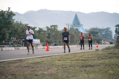 Yogyakarta, Endonezya - 25 Şubat 2024: Koşu yarışına katılanlar son kilometrede asfalt yolda yorulmaya başlıyorlardı. Sahilden Sahile etkinlikte.