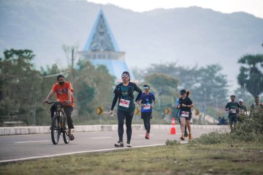 Yogyakarta, Endonezya - 25 Şubat 2024: Koşu yarışına katılanlar son kilometrede asfalt yolda yorulmaya başlıyorlardı. Sahilden Sahile etkinlikte.