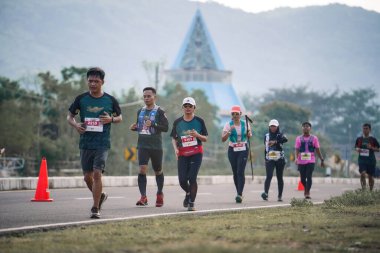 Yogyakarta, Endonezya - 25 Şubat 2024: Koşu yarışına katılanlar son kilometrede asfalt yolda yorulmaya başlıyorlardı. Sahilden Sahile etkinlikte.