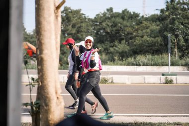 Yogyakarta, Endonezya - 25 Şubat 2024: Koşu yarışına katılanlar son kilometrede asfalt yolda yorulmaya başlıyorlardı. Sahilden Sahile etkinlikte.