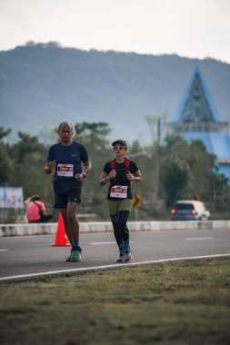 Yogyakarta, Endonezya - 25 Şubat 2024: Koşu yarışına katılanlar son kilometrede asfalt yolda yorulmaya başlıyorlardı. Sahilden Sahile etkinlikte.