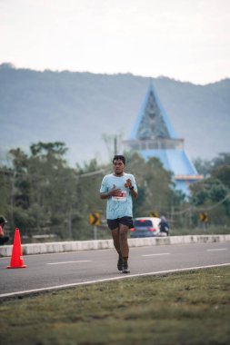 Yogyakarta, Endonezya - 25 Şubat 2024: Koşu yarışına katılanlar son kilometrede asfalt yolda yorulmaya başlıyorlardı. Sahilden Sahile etkinlikte.