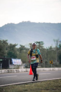 Yogyakarta, Endonezya - 25 Şubat 2024: Koşu yarışına katılanlar son kilometrede asfalt yolda yorulmaya başlıyorlardı. Sahilden Sahile etkinlikte.