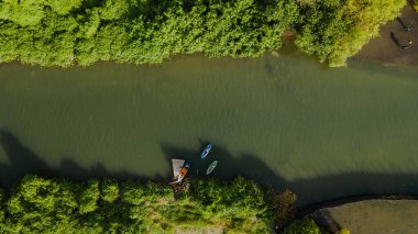 Hava görüntüsünde, nehrin ağzındaki kanoda kürek çeken birini görebilirsiniz. Bantul, Yogyakarta, Endonezya 'da yer alır..