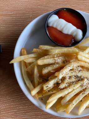 Kahve dükkanındaki masada patates kızartması yiyorum.