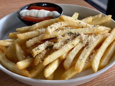 Kahve dükkanındaki masada patates kızartması yiyorum.