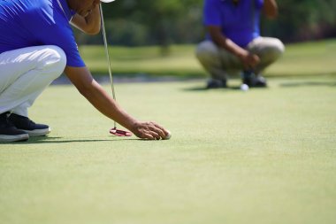 Golfçü topu golf sahasına koyuyor.