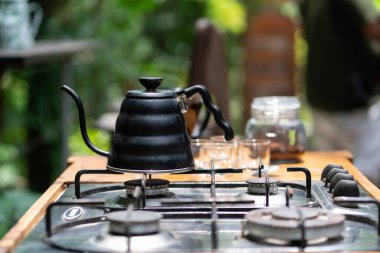 Çaydanlığın, bardakların ve kahve demleme ekipmanlarının estetik bir masada fotoğrafı..