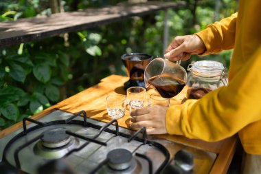 Koyu kahveyi cam sürahiden bardağa dolduruyorum..