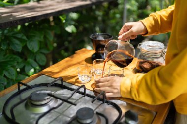 Koyu kahveyi cam sürahiden bardağa dolduruyorum..