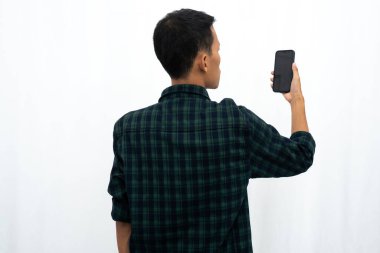 Elinde tuttuğu cep telefonuna bakan bir adamın arka görüntüsü