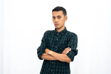 Sıradan yeşil kareli gömlek giyen Asyalı bir adam elleri karnında poz veriyor. İş fotoğrafı konsepti, havalı öğrenci. İzole edilmiş beyaz arkaplan.