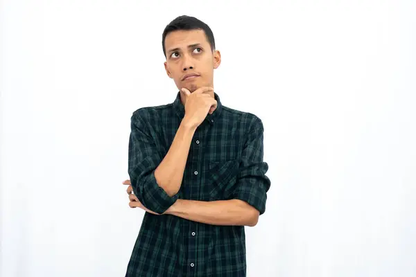 stock image Asian man wearing a casual green checkered shirt poses thinking, looking for ideas. Isolated white background.