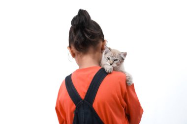 Küçük Asyalı bir kız kedi yavrusunu sevgiyle kucaklıyor. Sevimli. Beyaz arka planda izole edilmiş. Uluslararası kedi günü fotoğraf konsepti.