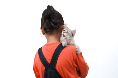 Küçük Asyalı bir kız kedi yavrusunu sevgiyle kucaklıyor. Sevimli. Beyaz arka planda izole edilmiş. Uluslararası kedi günü fotoğraf konsepti.