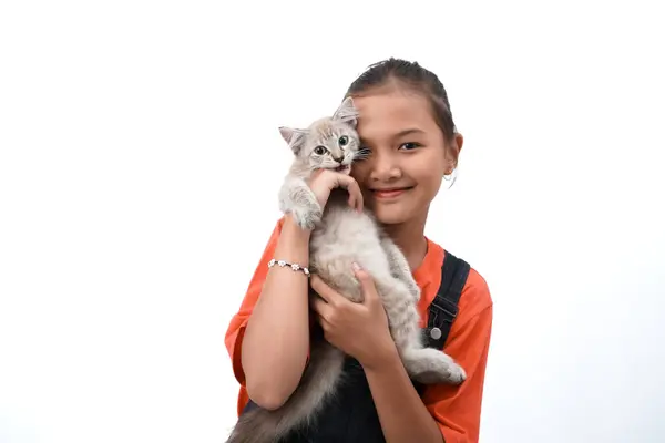 Küçük Asyalı bir kız kedi yavrusunu sevgiyle kucaklıyor. Sevimli. Beyaz arka planda izole edilmiş. Uluslararası kedi günü fotoğraf konsepti.