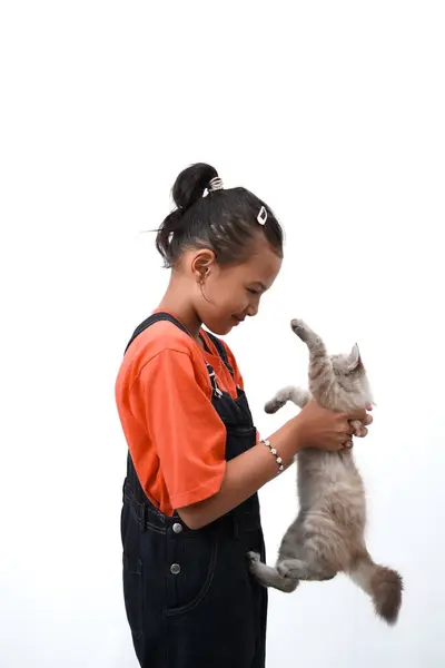 Küçük Asyalı bir kız kedi yavrusunu sevgiyle kucaklıyor. Sevimli. Beyaz arka planda izole edilmiş. Uluslararası kedi günü fotoğraf konsepti.