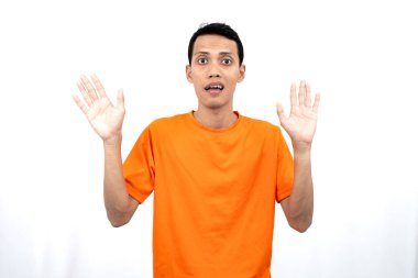 Turuncu tişört giyen genç bir Asyalı 'nın portresi bir arkadaşı ya da müşterisini sıcak bir şekilde selamlıyor. Beyaz arkaplanda izole.