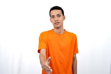 Turuncu tişört giyen genç bir Asyalı 'nın portresi bir arkadaşı ya da müşterisini sıcak bir şekilde selamlıyor. Beyaz arkaplanda izole.