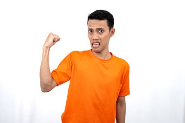 Turuncu tişört giyen Asyalı genç bir adamın portresi mutlu bir ifadeyle, iyi haberler aldığına şaşırdı. Beyaz arkaplanda izole.