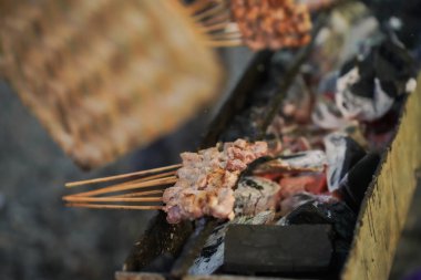 sate kambing or satay goat, lamb, Lamb or meat goat satay with charcoal ingredient on red fire grilling by people. traditional satay from yogyakarta, java, Indonesia cooking satay.