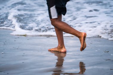 Turistler Kuta Sahili, Bali 'de koşu faaliyetleri yapıyorlar..