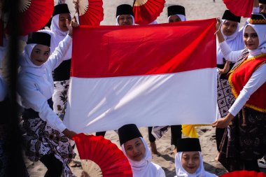 Bantul, Endonezya - 26 Ağustos 2023: Endonezya Muri Record, Montro dansçıları Muri plağını tamamladıktan sonra Endonezya kırmızı ve beyaz bayrağını göndere çektiler, binlerce katılımcıyla Montro dansı yaptılar.