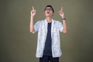 Gözlüklü genç Asyalı bir adam, aklına bir fikir geliyor. Ordu yeşil arka planında izole edilmiş..