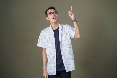 Gözlüklü genç Asyalı bir adam, aklına bir fikir geliyor. Ordu yeşil arka planında izole edilmiş..