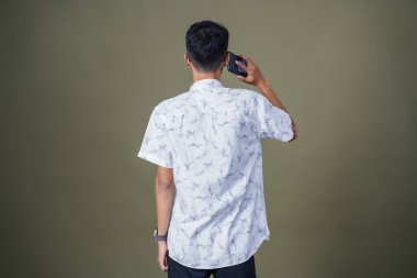 Arkadan konuşan genç bir adam görülmüş. Ordu yeşil arka planında izole edilmiş..