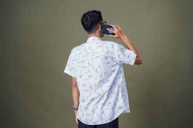 Arkadan konuşan genç bir adam görülmüş. Ordu yeşil arka planında izole edilmiş..