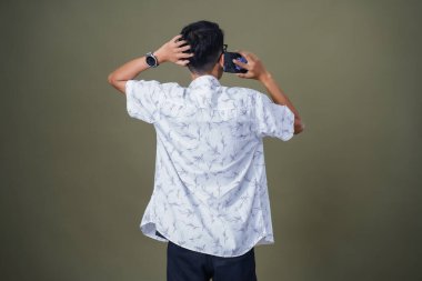 Arkadan konuşan genç bir adam görülmüş. Ordu yeşil arka planında izole edilmiş..