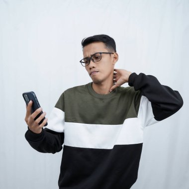 Akıllı telefon tutan gözlüklü, süveter giyen Asyalı genç bir adam. Beyaz arkaplanda izole.