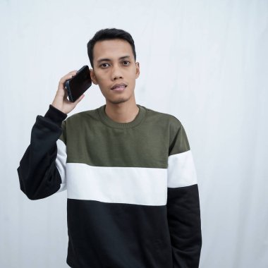 Gözlüklü, süveter giyen genç bir Asyalı telefon görüşmesi yapıyor. Beyaz arkaplanda izole.