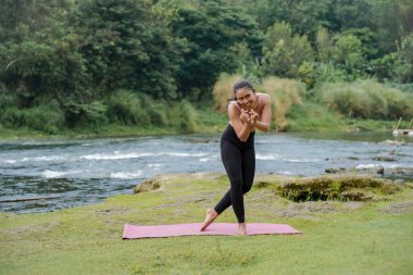 Isınmayı bitirdikten ya da kaslarını esnettikten sonra kahverengi tenli, ince Asyalı bir kızın mutlu ifadesi..
