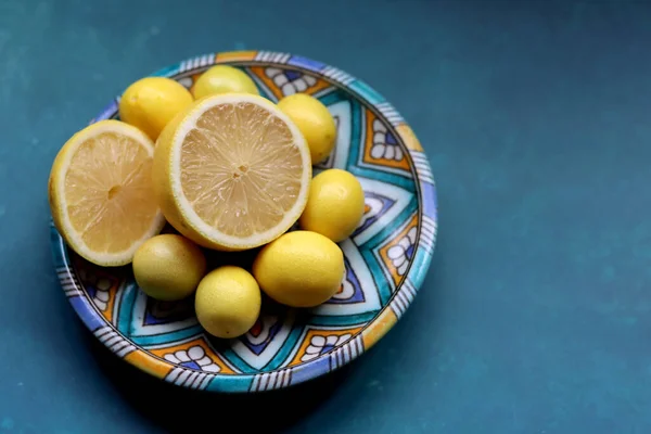 Fresh lemon fruit on a blue ceramic plate. Colorful still life with seasonal fruit. Healthy eating concept.