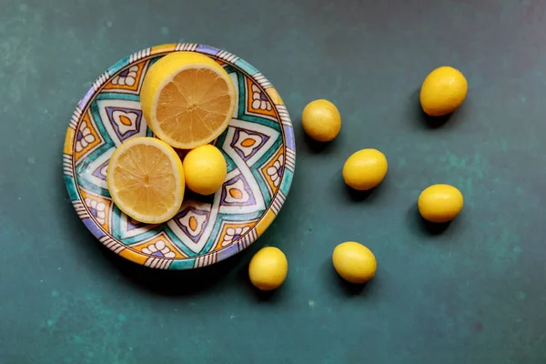 Fresh lemon fruit on a blue ceramic plate. Colorful still life with seasonal fruit. Healthy eating concept.