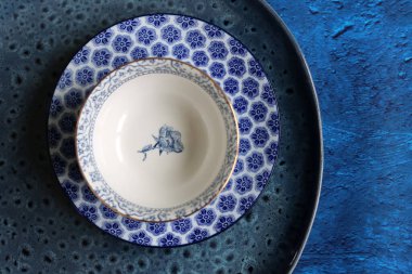 Decorative blue crockery on a textured background. Beautiful porcelain tableware.  
