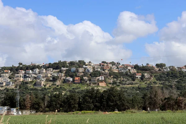 丘の上のかわいい町 イスラエルの村のカラフルな建物 緑の芝生 ふわふわの雲と青空 イスラエルの建築 中東の春 — ストック写真